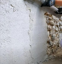Person applying Tradilys to a textured wall with a tool.